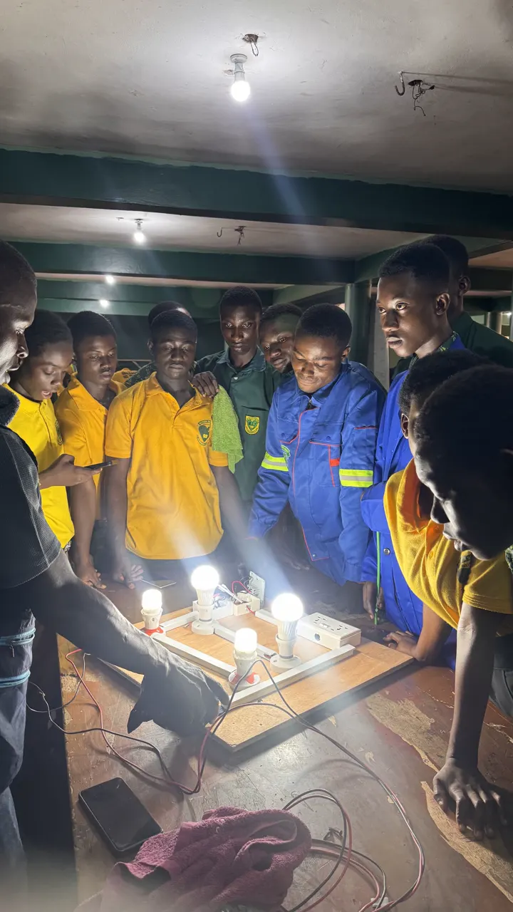Action SHTS students watching four lamps glow on the lighting circuit they wired on a practice board
